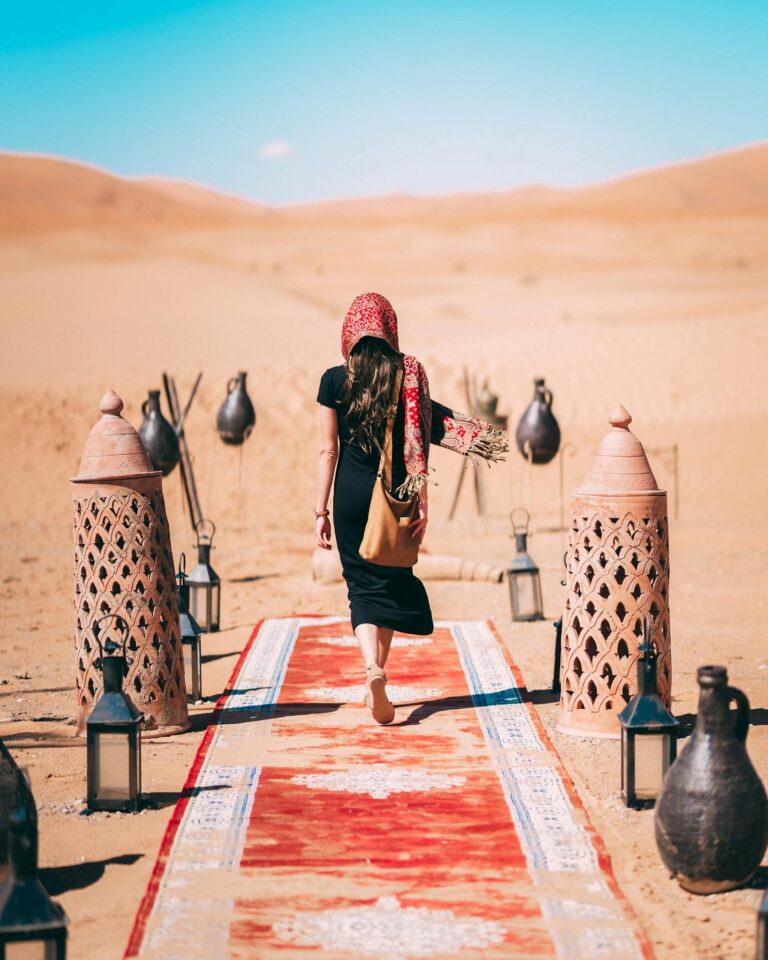 Woman in a black dress walking in Al Wahat Al Dakhla Desert, Egypt.